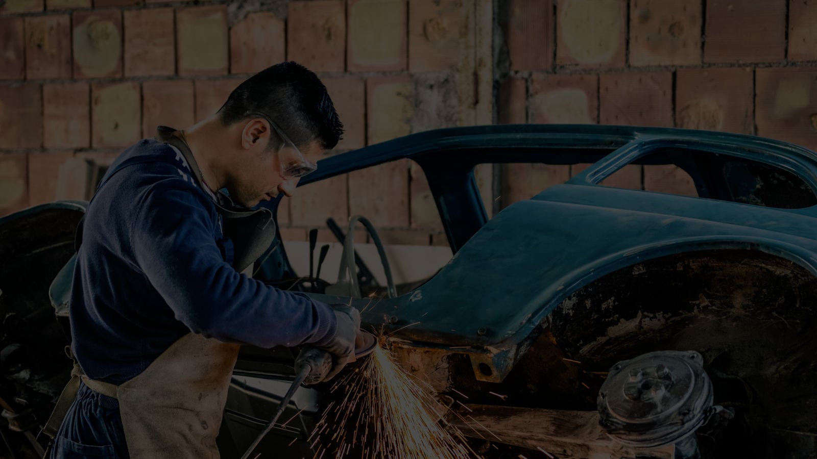 Worker grinding metal in a workshop